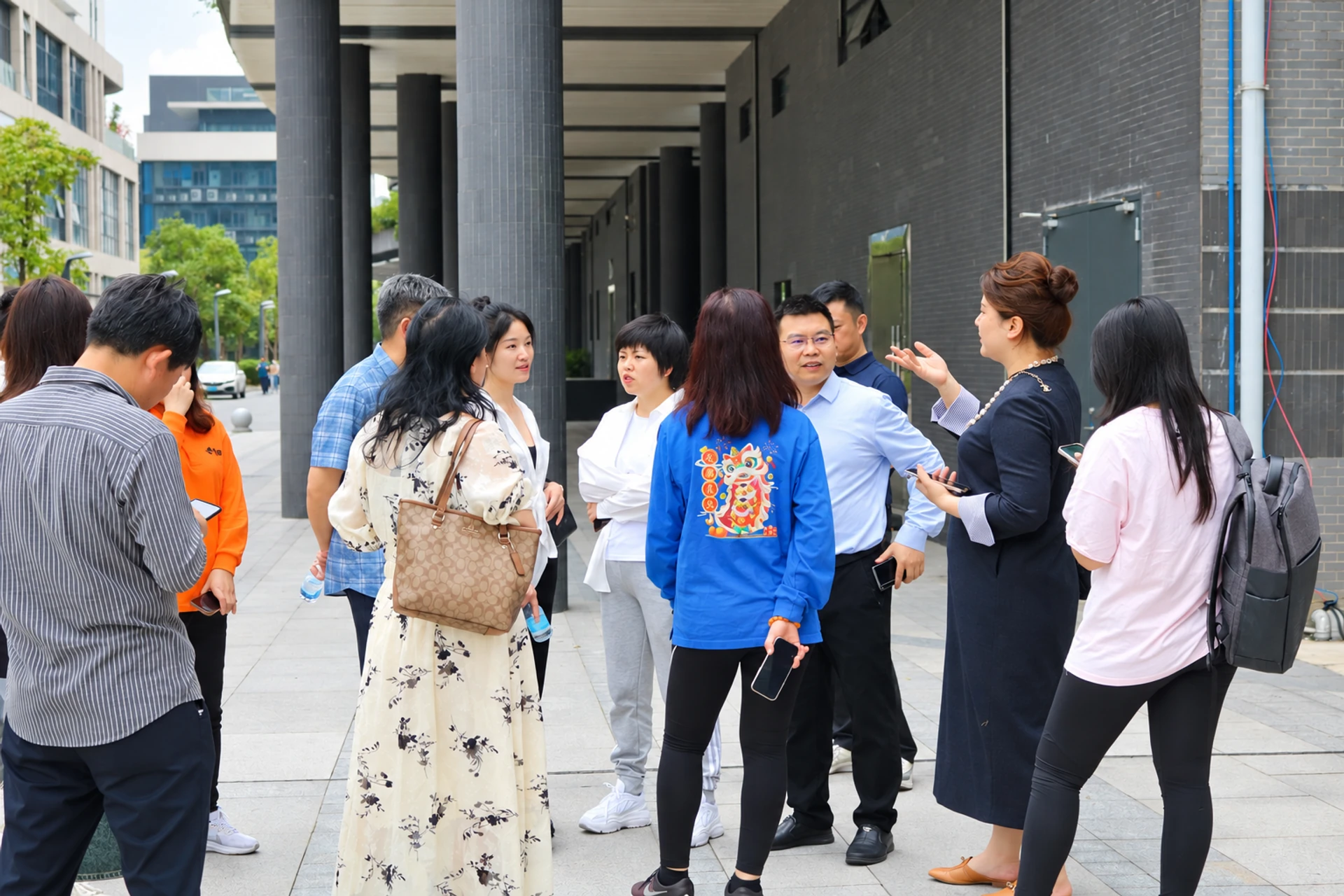 客户在工厂建筑外与工作人员交流